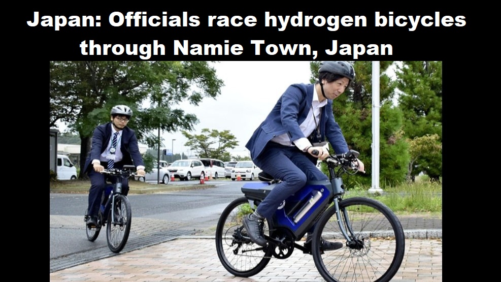 Japan: ambtenaren racen op de waterstoffietsen door Namie Town, Japan